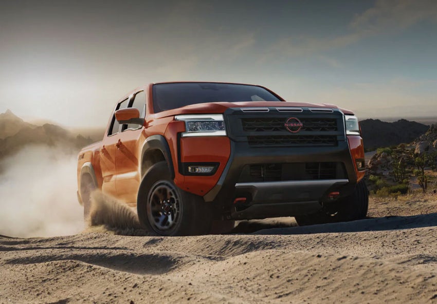 2026 Nissan Frontier parked on a rugged trail, showcasing its bold design and off-road readiness